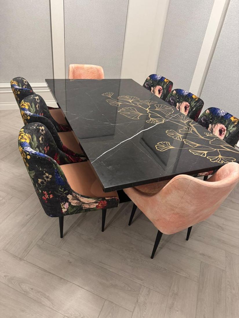 Black marble dining table with a gold ginkgo design